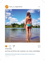 Sieviete peldkostīmā stāv upē ar seju pret mežu