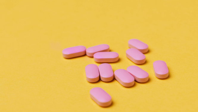 Rozā tabletes uz dzeltena fona