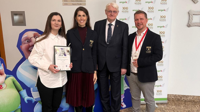 Cilvēki pozē pie Ā.T.R.I. varoņi plakāta saņemot apbalvojumu