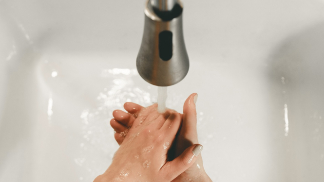 Sieviete mazgā rokas izlietnē