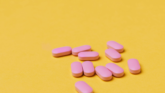Rozā tabletes uz dzeltena fona
