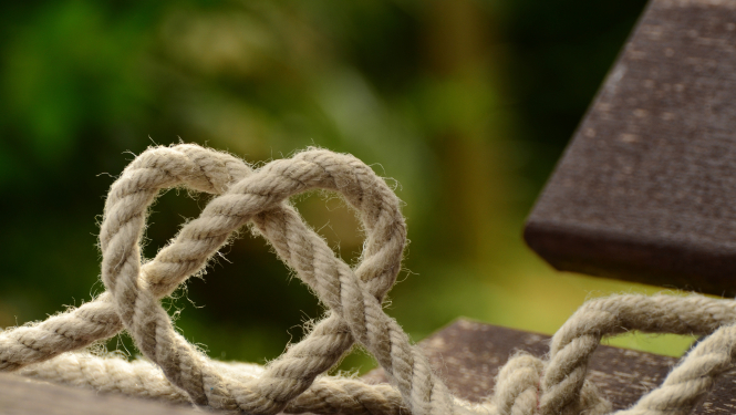 brīvā dabā koka dēlis uz kura sasieta aukla sirds formā