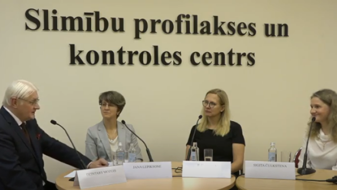 fonā SPKC uzraksts un priekšplānā četras runas personas tiešraidē