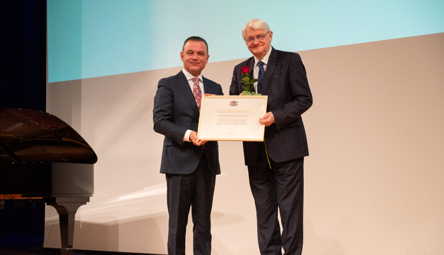Dzintars Mozgis saņem pateicības rakstu uz skatuves