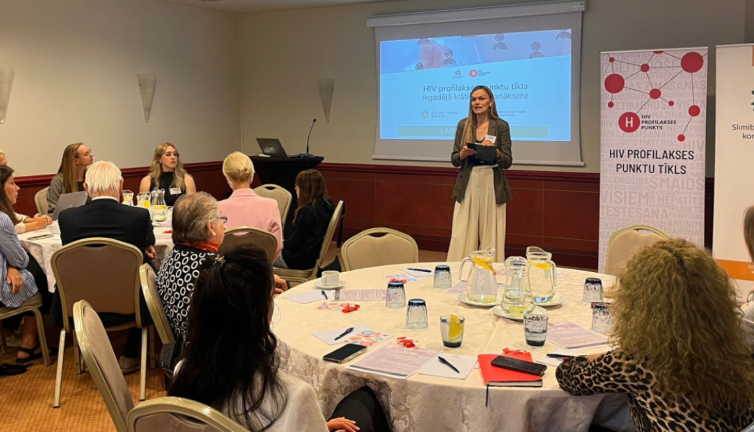 Hiv profilakses punktu pārstāvju sanākmes dalībnieki sēž pie galdiņiem