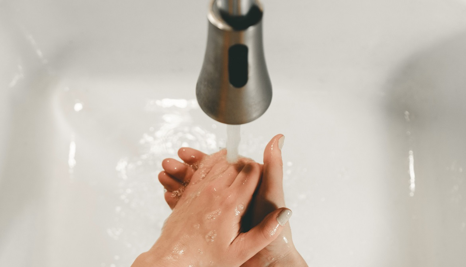 Sieviete mazgā rokas izlietnē