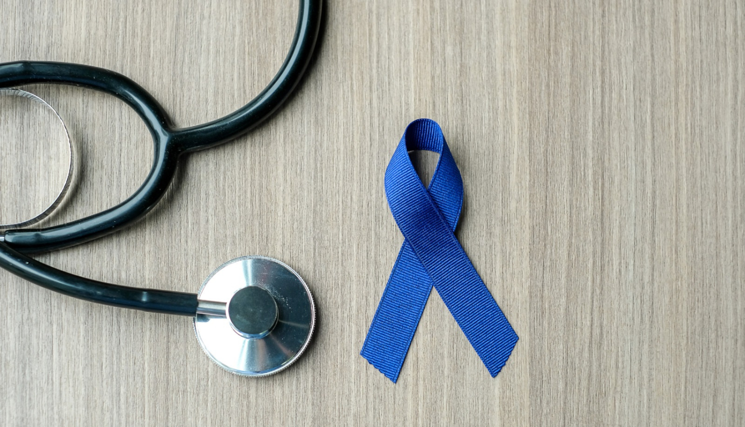 uz pelēka fona ārsta fonendoskops  un zila lentīte