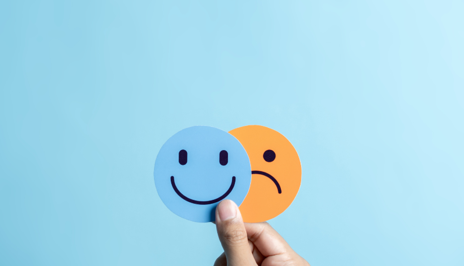 Uz zila fona smaidīgas un bēdīgas sejas ikonas