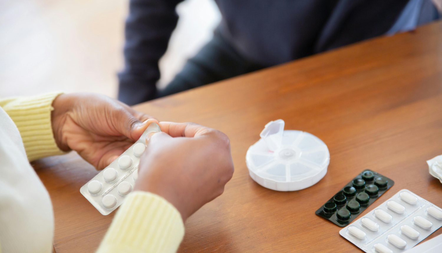 sieviete ar medikamentu plāksni rokās