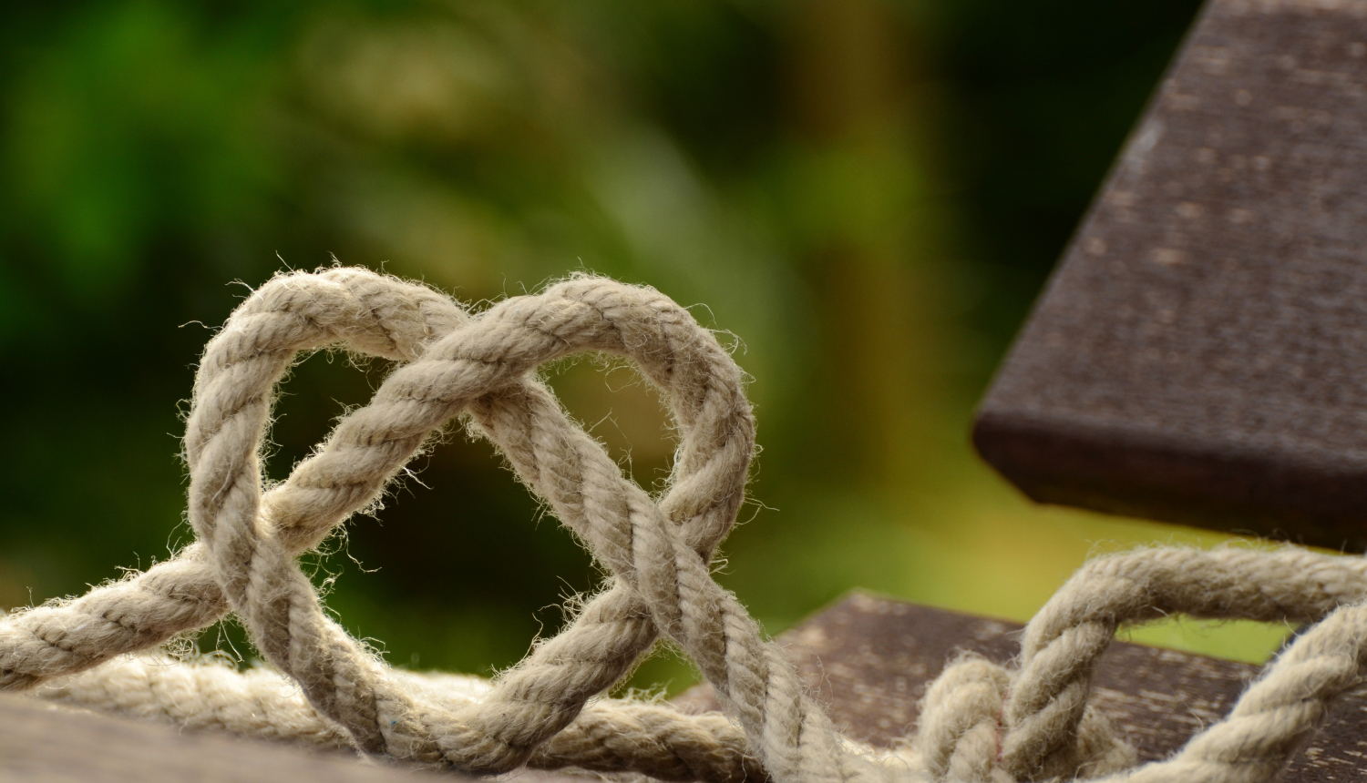 brīvā dabā koka dēlis uz kura sasieta aukla sirds formā